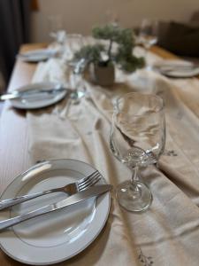 einen Tisch mit einer weißen Platte und einem Weinglas in der Unterkunft Apartment U345 - Aparthotel Vučko Jahorina - private host in Jahorina