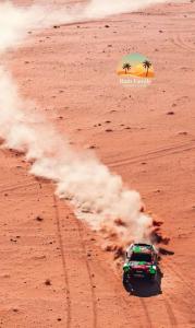 a truck driving in the desert with smoke at wadi rum tala camp in Wadi Rum