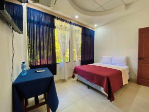 a bedroom with a bed and a table and a window at Hotel D' Palacio Real in San Miguel