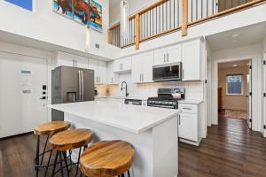 a kitchen with white cabinets and a counter with stools at Quarry B5 in Whitefish
