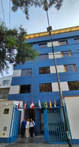 a group of people standing in front of a blue building at Hostal Winya in Lima