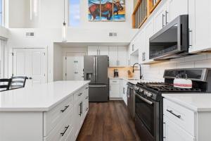 a kitchen with white cabinets and a black stove top oven at Quarry B5 in Whitefish