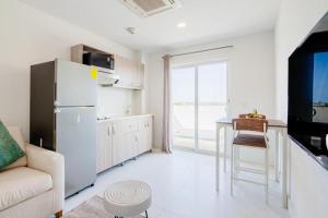 eine Küche mit einem Kühlschrank und einem Tisch im Zimmer in der Unterkunft Arubas Life 403 in Noord