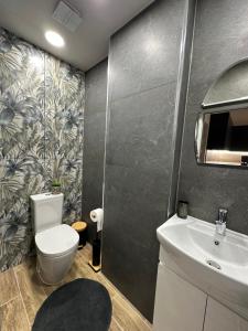 ein Badezimmer mit Toilette und Waschbecken in der Unterkunft Georgia Suites in Lyubimets + 33 Fotos