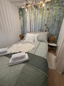 a bedroom with two beds with trees on the wall at Polana House in Niedźwiada