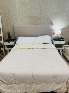 a bedroom with a large white bed with two night stands at Clorinda Departamentos in Clorinda
