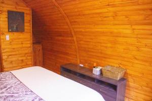 a bedroom with a bed in a wooden wall at Silua Eco glamping in Tibasosa