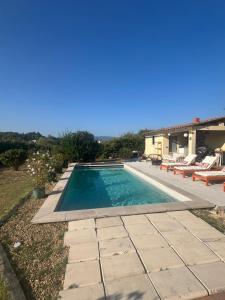 ein Swimmingpool mit Stühlen und ein Haus in der Unterkunft Suite privée tout confort in Gargas + 6 Fotos