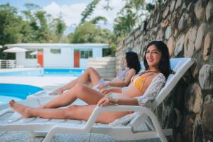 zwei Frauen auf Liegestühlen am Pool in der Unterkunft Hotel Real Park in Tarapoto + 15 Fotos