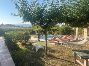 Ein Mann steht neben einem Baum mit einer Hängematte. in der Unterkunft Suite privée tout confort in Gargas