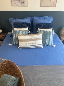 ein blaues Bett mit einem Stapel Kissen darauf in der Unterkunft Suite privée tout confort in Gargas