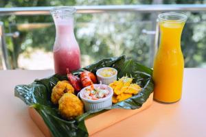 ein Tablett mit Essen auf einem Tisch mit zwei Getränken in der Unterkunft Hotel Real Park in Tarapoto
