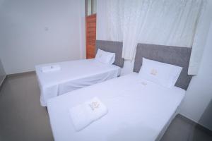 zwei Betten in einem Zimmer mit weißen Laken und Kissen in der Unterkunft Hotel Real Park in Tarapoto