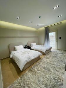 two beds in a large room with a window at desert rose hotel-فندق ديزرت روز in Siwa +5 photos