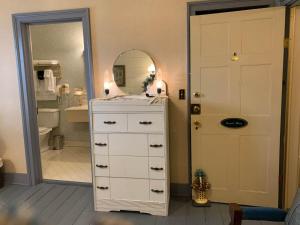 ein Badezimmer mit einer weißen Kommode und einem Spiegel in der Unterkunft Laura's Room in Jonesborough