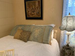 ein Schlafzimmer mit einem Bett mit Kissen und einer Lampe in der Unterkunft Laura's Room in Jonesborough