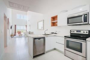 a white kitchen with a stove and a microwave at Arubas Life 303 in Noord