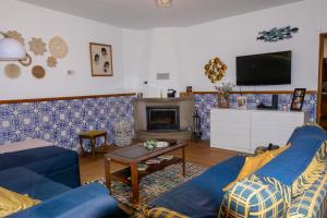 a living room with two blue couches and a tv at Edu Stay Mondego in São Pedro de Alva