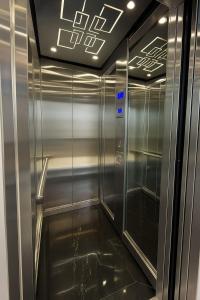 a elevator in a building with a shiny metal wall at Damani Studios in Foz do Iguaçu