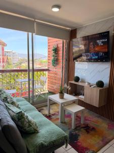 a living room with a couch and a large window at Dep 3 habitaciones 1,5 baños céntrico parking wif TV en habitaciones in Rancagua