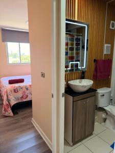 a bathroom with a sink and a bed at Dep 3 habitaciones 1,5 baños céntrico parking wif TV en habitaciones in Rancagua