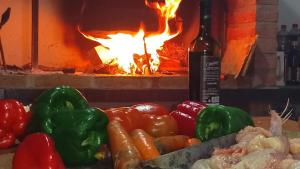 a pile of vegetables in front of a fire oven at Pequeño Complejo Pachamama - Casa Aire in El Ceibal +7 photos