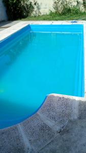 a swimming pool with blue water and rocks around it at Pequeño Complejo Pachamama - Casa Aire in El Ceibal