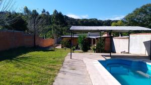 a backyard with a swimming pool and a fence at Pequeño Complejo Pachamama - Casa Aire in El Ceibal