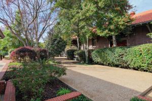 ein Haus mit Bäumen und Sträuchern und einem Bürgersteig in der Unterkunft Riverview Condo - 1bed 1&5bath, Downtown Natchez, Washer & Dryer in Natchez