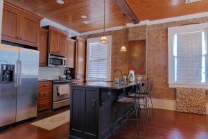 eine Küche mit Kühlschrank und Theke mit Hockern in der Unterkunft Riverview Condo - 1bed 1&5bath, Downtown Natchez, Washer & Dryer in Natchez