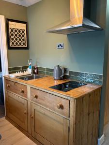 a kitchen with a sink and a stove at Cute & Funky One Bed, Salisbury, UK in Old Sarum
