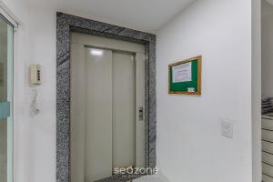 a elevator in a building with a sign on the wall at Apto 2 Quartos a 200 m da Praia MAO0203 in Cururupe