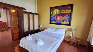ein Schlafzimmer mit einem Bett und einem Gemälde an der Wand in der Unterkunft Paraiso Escondido Lamas in Lamas