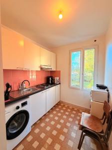 a kitchen with a sink and a washing machine at Maison Bon Séjour in Livry-Gargan