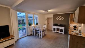a kitchen with a table and a dining room at Ferienhaus Klippenbarsch in Dornum
