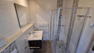 a bathroom with a sink and a glass shower at Ferienhaus Klippenbarsch in Dornum +25 photos