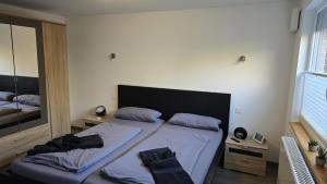 a bedroom with a bed and a mirror at Ferienhaus Wattwurm in Dornum