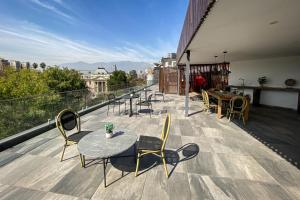a patio with tables and chairs on a balcony at Apart Hotel Dresden in Santiago