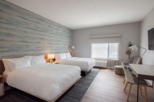 ein Hotelzimmer mit zwei Betten und einem Schreibtisch in der Unterkunft TownePlace Suites Dayton Beavercreek in Beavercreek