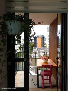 a table and chair on a balcony with a view of a building at Moira Ecolodge - Armenia Laureles in Armenia +36 photos