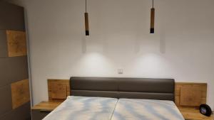 a bed in a room with a white wall at Ferienhaus Strandschnecke in Dornumersiel