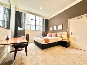 une chambre avec un lit, un bureau et un ordinateur dans l'établissement Perfect City Pad in Heritage Complex, à Auckland
