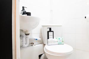 un baño con inodoro y lavabo en Beautiful new build studio in London, en Sutton