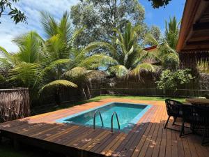 una piscina en una terraza junto a una casa en Corumbau Bangalôs, en Prado