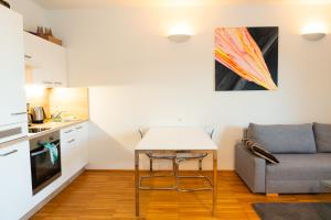 - une cuisine avec une table et un canapé dans une chambre dans l'établissement Modernes Apartment in der Innenstadt Klagenfurt, à Klagenfurt am Wörthersee 12 autres photos