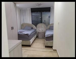 ein Schlafzimmer mit zwei Betten und einem Fenster in der Unterkunft Stunning house in romema jerusalem in Gedera