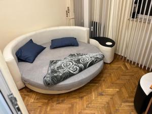 een slaapkamer met een bed met een deken erop bij Central Home Apartment in Craiova +7 foto's