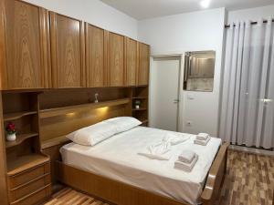 a bedroom with a large bed with wooden cabinets at Eyar house in Kamëz