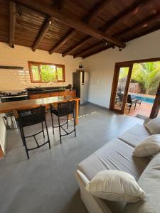 Una cocina y una sala de estar con mesa y sillas. en Corumbau Bangalôs, en Prado