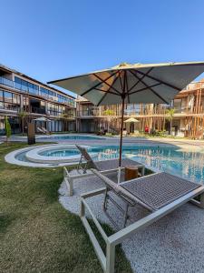 - une piscine avec un parasol, 2 chaises et une table dans l'établissement Beira Mar Naay Porto de Pedras Tatuamunha Palm 10, à Tatuamunha